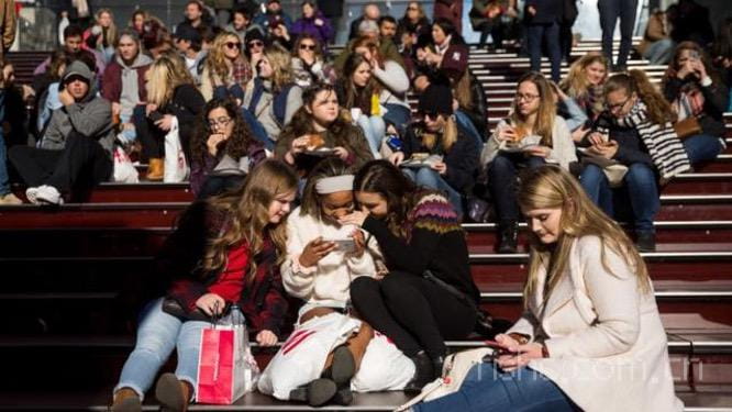 A group of teens look at a photograph they_y.jpg